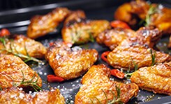 Blech mit mehreren saftigen Fleischstücken und Rosmarin